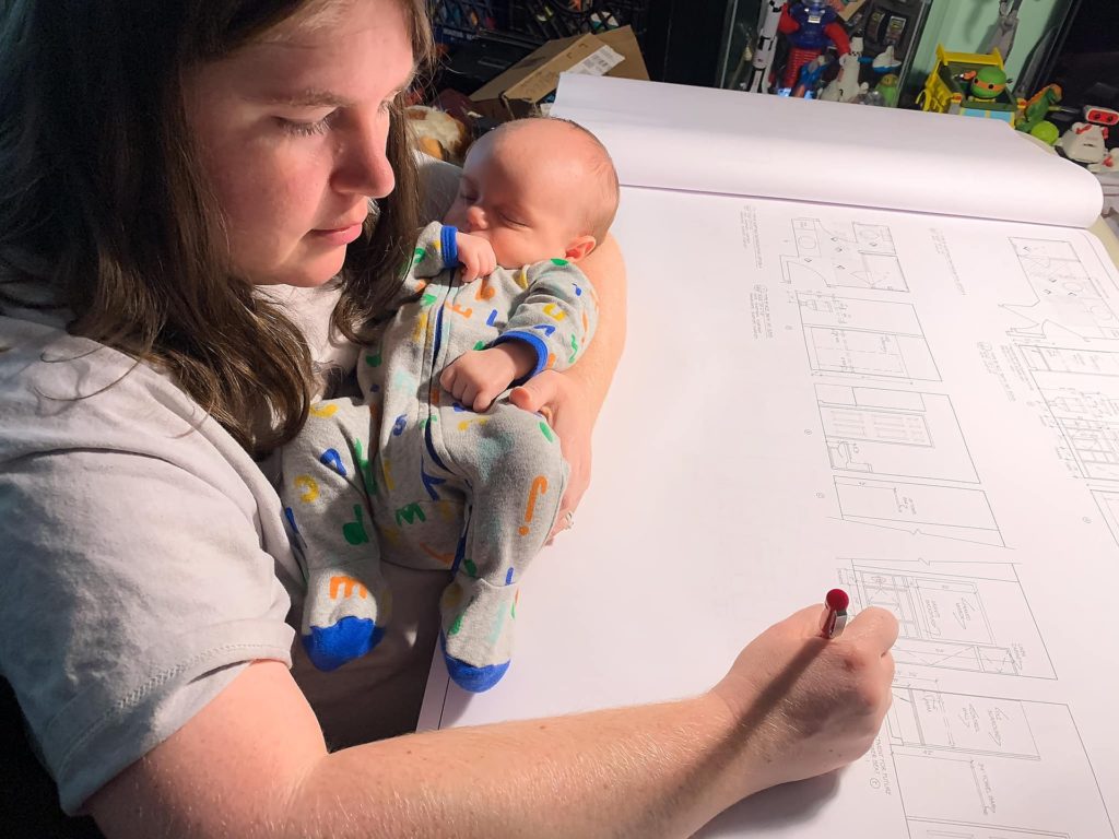 Adrienne holding child while working